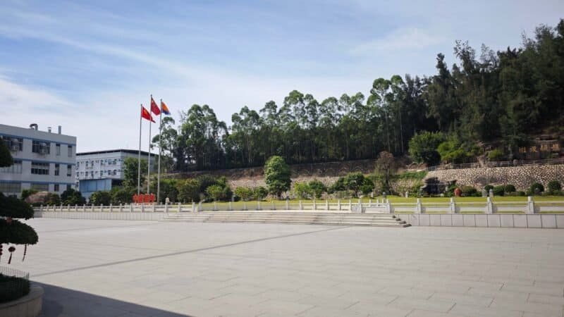 Kangbai Nian OEM factory outdoor yard, professional cosmetic manufacturing factory exterior venue, large production plant parking and storage area